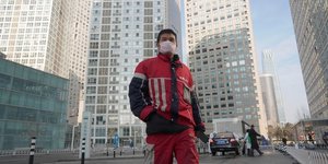Coronavirus / Covid-19 : un livreur KFC marche dans un complexe commercial situ dans le quartier des affaires de Beijing en Chine