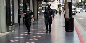 Coronavirus : des officiers du Los Angeles Police Department (LAPD) portent un masque, alors qu'ils patrouillent sur le Hollywood Boulevard, à Los Angeles, en Californie