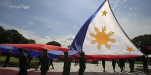Des soldats hissent le drapeau national des philippines lors d'une repetition